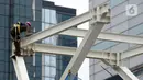 Pekerja menyelesaikan proyek Tugu Tenaga Kesehatan di Jembatan Penyeberangan Orang (JPO) Sudirman, Jakarta, Jumat (12/11/2021). Tugu Tenaga Kesehatan dibangun sebagai monumen perjuangan dan pengorbanan tenaga medis dalam menangani COVID-19. (merdeka.com/Imam Buhori)