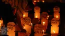 Aktivis menyalakan lilin diantara replika nisan korban pelanggaran HAM masa lalu saat peringatan 19 tahun reformasi di Galeri Cipta 2 TIM, Jakarta, Jumat (12/5). Aksi ini diikuti puluhan aktivis. (Liputan6.com/Helmi Fithriansyah)