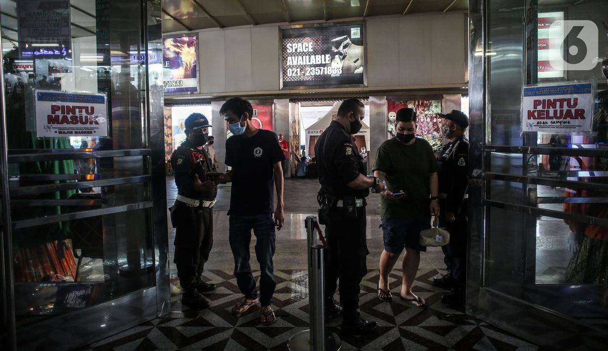 Warga menunjukan surat vaksin kepada petugas yang berjaga di Pasar Tanah Abang, Jakarta, Selasa (27/7/2021). Pasar Tanah Abang yang kembali dibuka mulai Senin (26/7) mewajibkan pengunjung serta pedagang menunjukkan sertifikat vaksinasi COVID-19 untuk masuk ke pasar. (Liputan6.com/Johan Tallo)