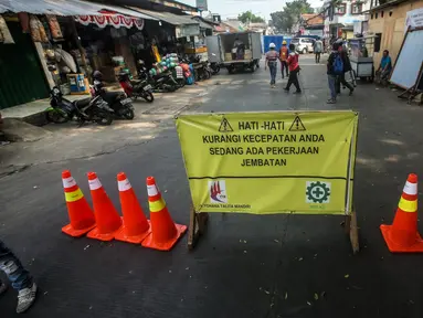 Akses jalan diblokir saat proses revitalisasi Jembatan Cibubur, Jakarta, Selasa (2/8/2022). Revitalisasi dilakukan untuk mengantisipasi risiko banjir akibat rendahnya muka jembatan serta risiko kecelakaan akibat tidak adanya trotoar. (Liputan6.com/Faizal Fanani)