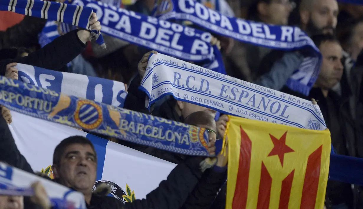 Aksi suporter Espanyol membentangkan bendera Catalan saat laga Espanyol melawan Barcelona di RCDE Stadium, Cornella de Llobregat, (17/1/2018). Barcelona kalah 0-1. (AFP/Josep Lago)