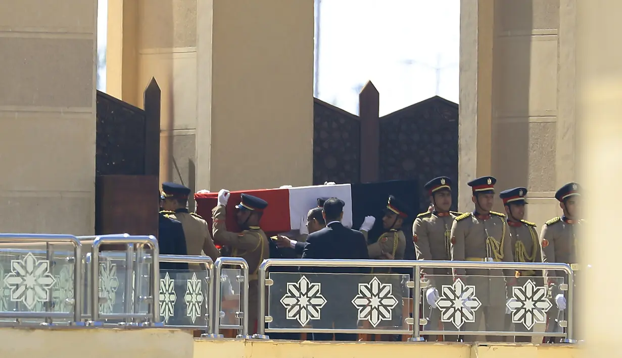 Para penjaga kehormatan membawa peti jenazah mantan presiden Hosni Mubarak saat upacara pemakaman di Masjid Tantawi, Kairo, Mesir, Rabu (26/2/2020). Mubarak menghabiskan kehidupannya di balik jeruji besi dan rumah sakit militer sebelum akhirnya bebas pada tahun 2017.  (Khaled DESOUKI/AFP)
