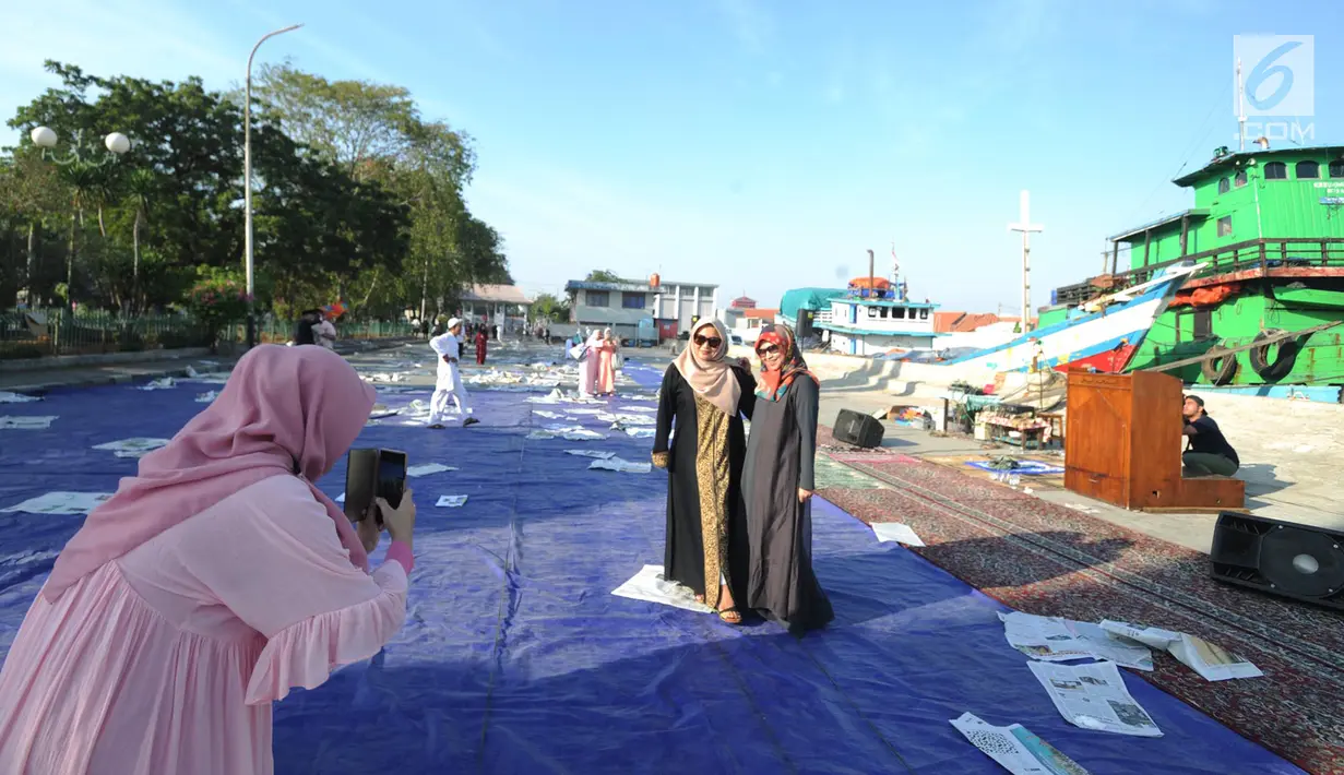 Umat muslim berfoto usai melaksanakan salat Idul Fitri di kawasan Pelabuhan Sunda Kelapa, Jakarta, Rabu (5/6/2019). Umat muslim seluruh Indonesia merayakan Hari Raya Idul Fitri 1440 Hijriah setelah sebelumnya melaksanakan puasa Ramadan selama sebulan penuh. (merdeka.com/Arie Basuki)