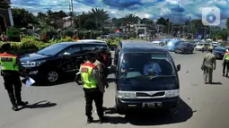 Petugas gabungan melakukan pemeriksaan surat rapid test antigen bagi wisatawan yang masuk ke wilayah Puncak di Gadog, Bogor, Kamis (24/12/2020). Ribuan kendaraan terjebak kemacetan akibat razia masker dan pemeriksaan hasil rapid test antigen tersebut. (merdeka.com/Arie Basuki)