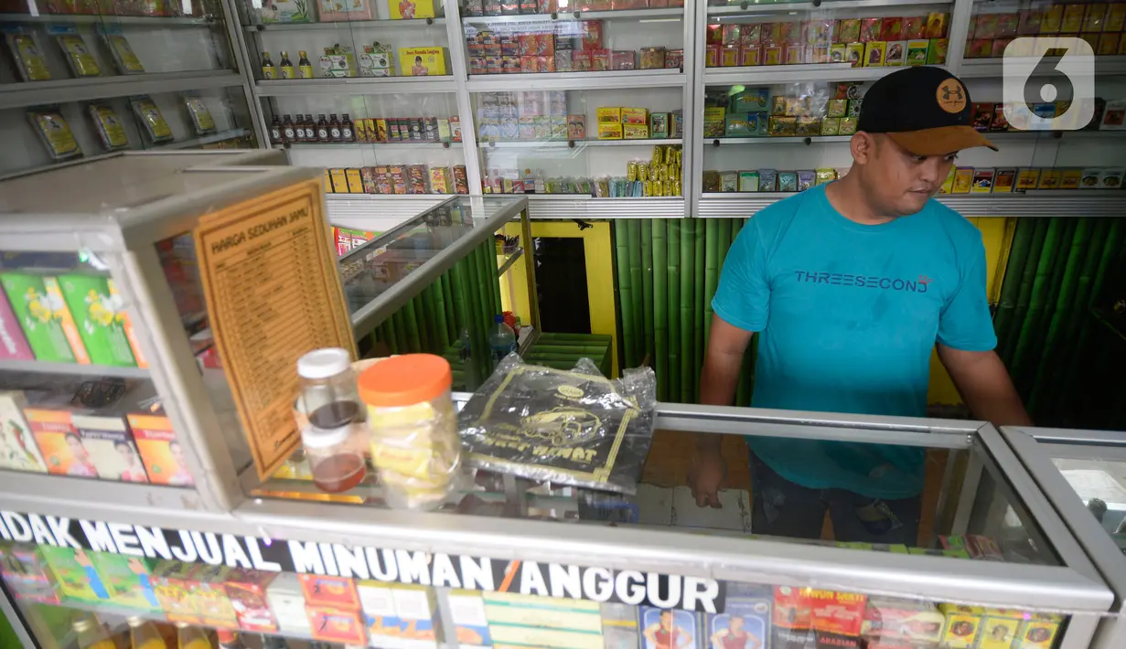 Hendri (37) penjual jamu aduk menunggu pembeli di kawasan Pamulang, Tangerang Selatan, Banten, Senin (289/2020). Menurutnya penjualan jamu aduk pada masa musim pandemi Covid 19 satu bulan ini penjualan meningkat hingga 200 persen dibandingkan bulan sebelumnya. (merdeka.com/Dwi Narwoko)