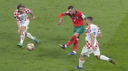 Keadaan imbang membuat Maroko terus melancarkan serangan. Hakim Ziyech (tengah) yang dikawal Luka Modric (kiri) berhasil melakukan tendangan ke gawang Kroasia, namun upaya tersebut masih gagal. (AP Photo/Martin Meissner)