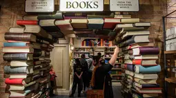 Orang-orang berbelanja di dalam toko Harry Potter Terbesar di Dunia saat resmi dibuka di New York City, Kamis (3/6/2021). Pengunjung bisa menjelajahi 15 area dengan tema berbeda, produk eksklusif, serta elemen interaktif yang mengingatkan pada dunia sihir Harry Potter. (Angela Weiss / AFP)