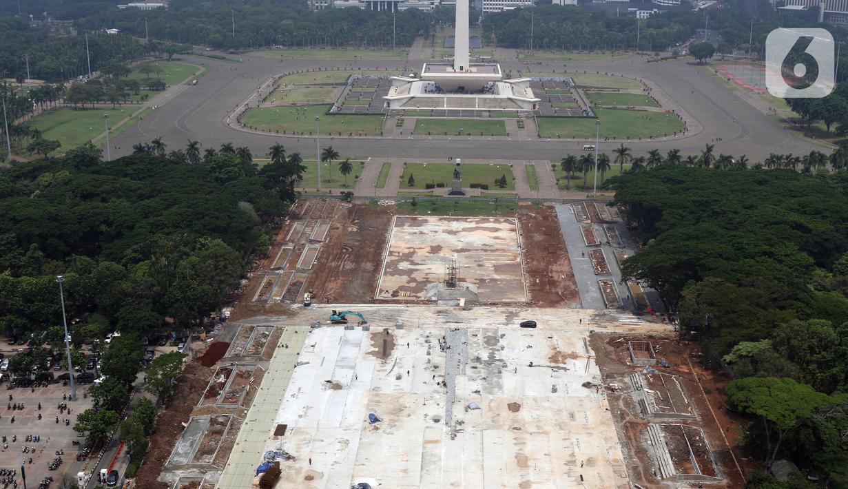 Aktivitas pengerjaan proyek revitalisasi Taman Sisi Selatan Monumen Nasional dilihat dari ketinggian, Jakarta, Minggu (19/1/2020). Proses revitalisasi dimulai dengan penebangan ratusan pohon di taman selatan Monas dan menjadikan kawasan tersebut terlihat gersang. (Liputan6.com/Helmi Fithriansyah)