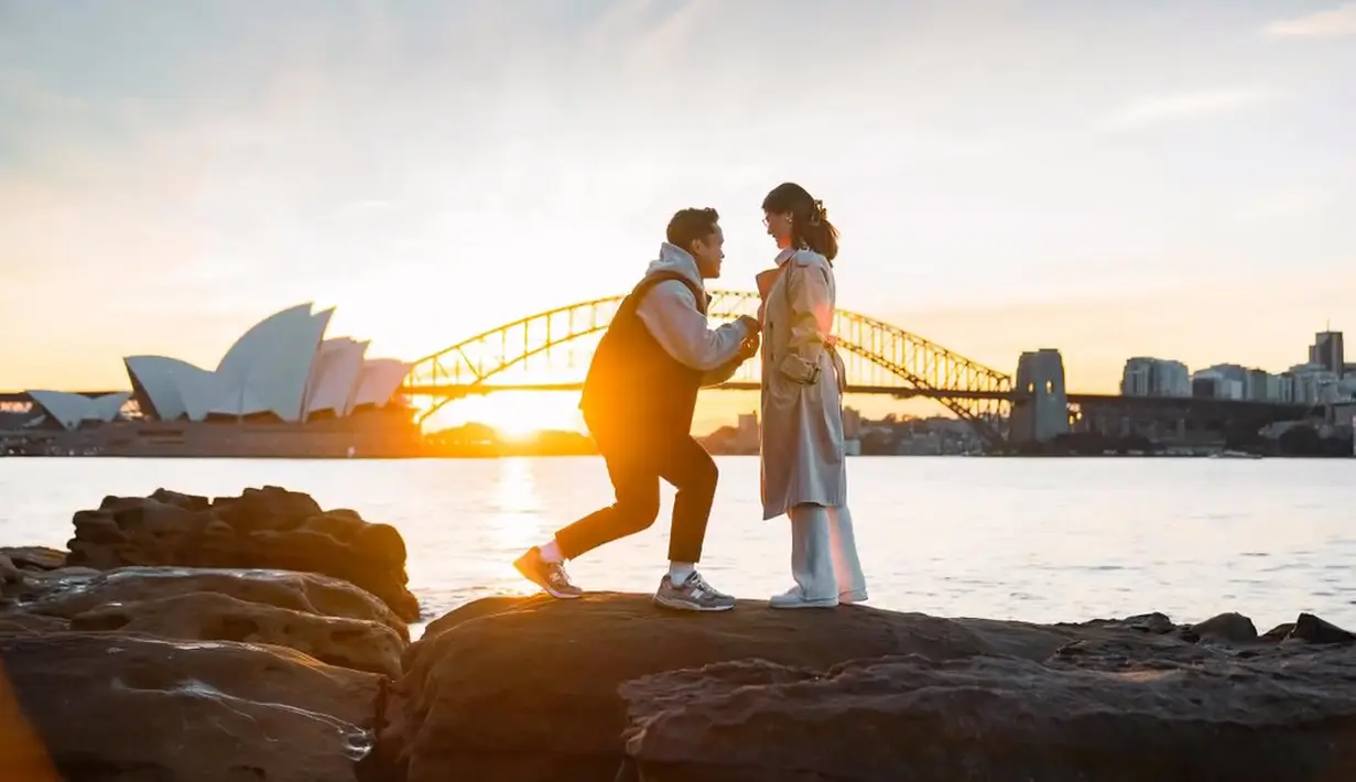 Momen Ginting melamar sang kekasih dengan berlatar pemandangan Sydney Harbour Bridge. Pemandangan yang indah menambah suasana makin romantis banget. Tampak dalam video singkatnya, Ginting bersimpuh didepan sang kekasih.  Ginting lantas memasangkan cincin ke jari manis sang kekasih. [Instagram/sinisukanthony]