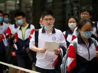 Para siswa memasuki sekolah untuk mengikuti Ujian Masuk Perguruan Tinggi Nasional (NCEE) hari pertama yang dikenal sebagai “Gaokao” di Beijing (7/6/2021).  (AFP/Wang Zhao)
