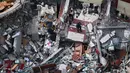 <p>Warga Palestina memeriksa bangunan hancur yang menampung kantor The Associated Press dan media lainnya, setelah terkena serangan udara Israel pekan lalu, di Kota Gaza, Jumat (21/5/2021). Israel dan Hamas telah sepakat untuk gencatan senjata setelah 11 hari pertempuran. (AP Photo/Hatem Moussa)</p>