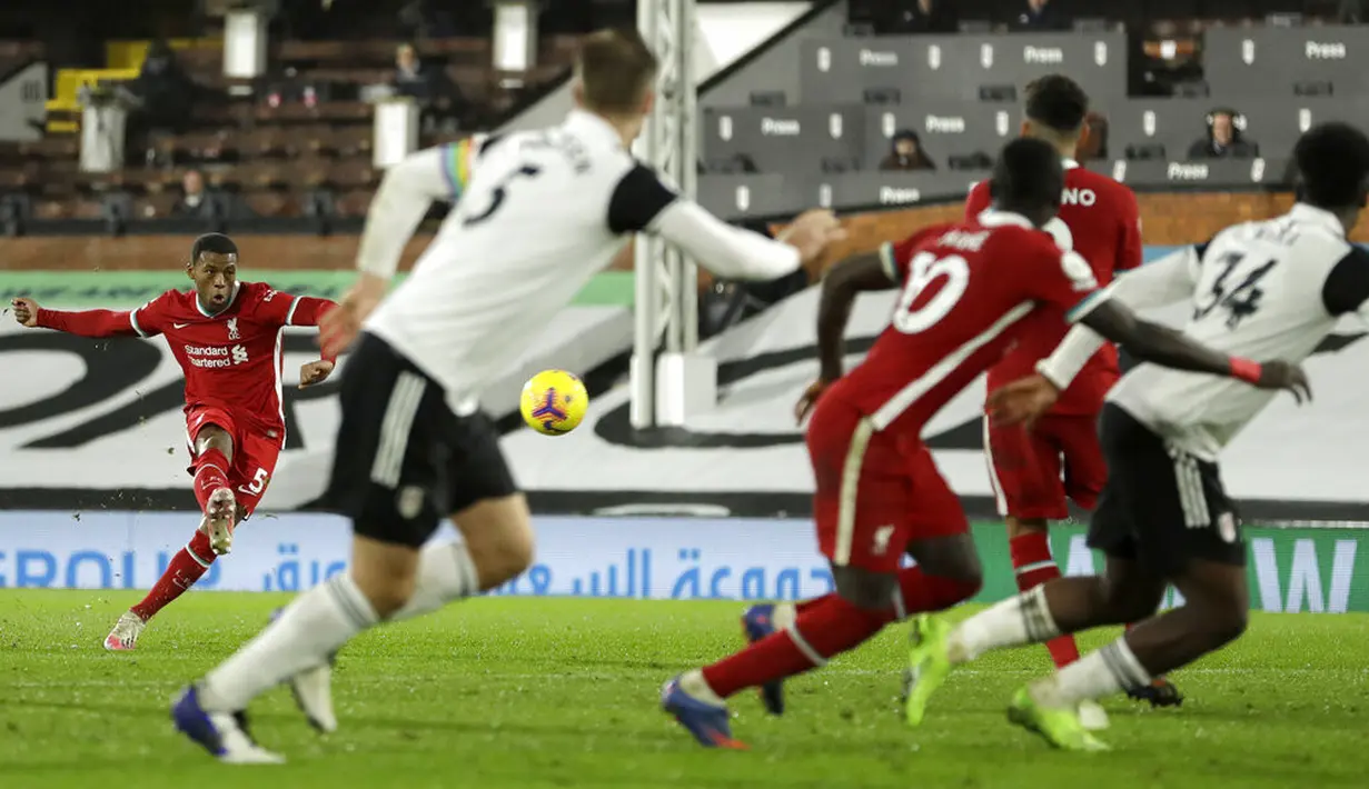 Pemain Liverpool Georginio Wijnaldum (kiri) melakukan tendangan bebas saat melawan Fulham pada pertandingan Liga Premier Inggris di Stadion Craven Cottage, London, Minggu (13/12/2020). Liverpool dan Fulham bermain imbang 1-1. (AP photo/Matt Dunham, Pool)
