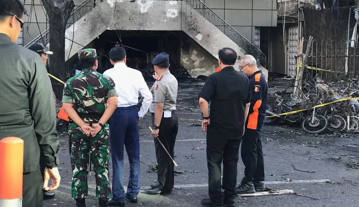 Presiden Joko Widodo (Jokowi) mendengarkan penjelasan Kapolri Jenderal Tito Karnavian terkait situasi dan kondisi saat meninjau Gereja Kristen Indonesia yang menjadi lokasi ledakan bom di Jalan Arjuna, Surabaya, Minggu (13/5). (Liputan6.com/Istimewa)