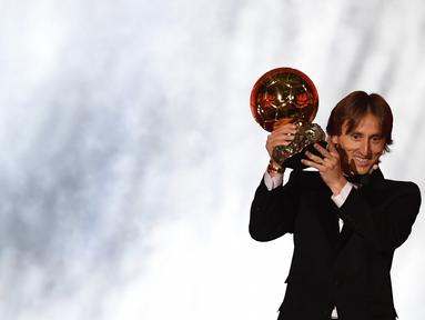 Gelandang Real Madrid asal Kroasia, Luka Modric, menunjukan trofi saat malam penghargaan Ballon d'Or di Paris, Senin (3/12). Dirinya berhasil meraih gelar Ballon d'Or. (AFP/Franck Fife)