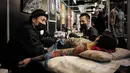 Seorang pria berbaring saat tubuhnya di tato dalam acara Konvensi Tattoo Paris (Mondial du Tatouage) di Grand Halle de la Villette di Paris (8/3). Acara ini menjadi ajang berkumpulnya bagi para penyuka, penggemar dan seniman tato. (AFP/Philippe Lopez)