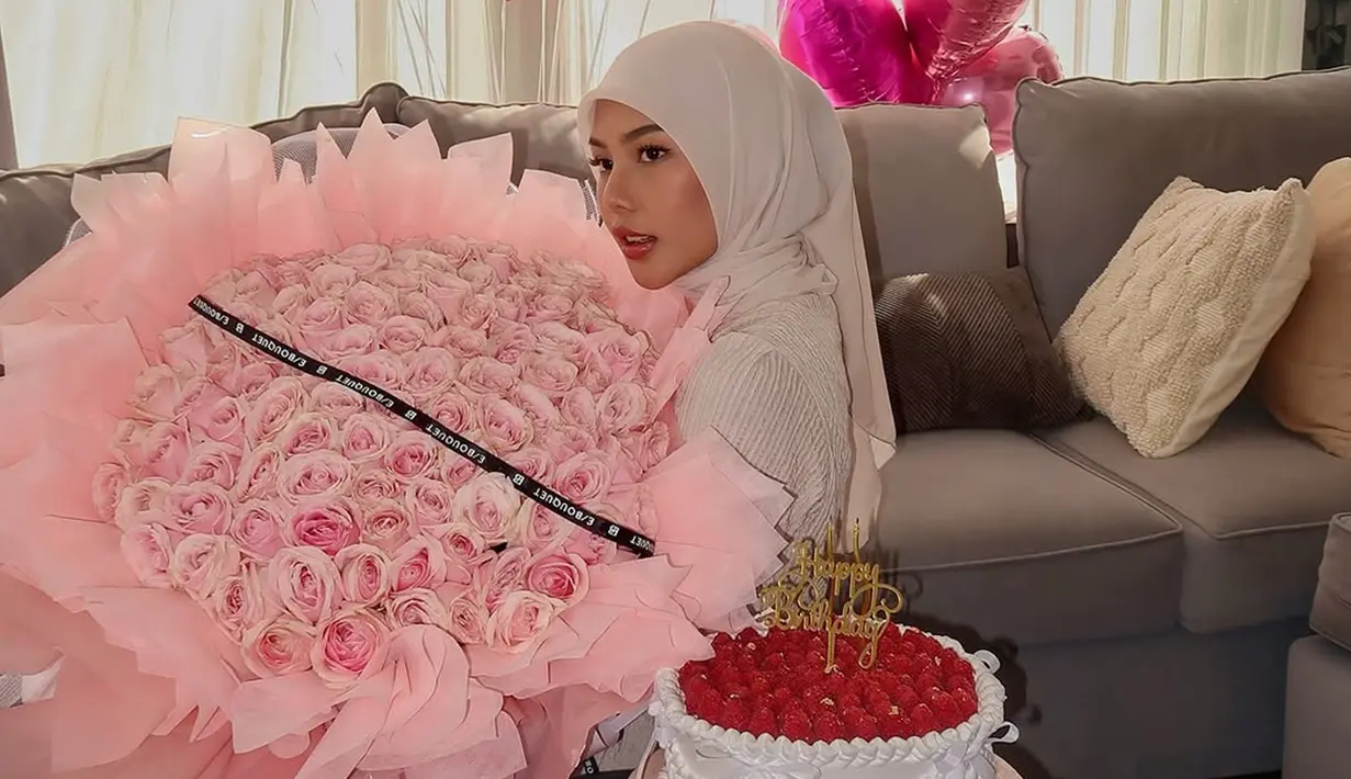 Setelah mendapatkan kejutan di Sea World, Dara Arafah kemudian mendapatkan kejutan lagi. Dara mendapatkan buket bunga mawar pink besar dan kue tart stroberi dari teman-temannya. Rumahnya didesain simpel dengan balon-balon warna putih dan merah muda. Menginjak usia 25 tahun, sahabat Keanu Agl ini makin istikamah menutup auratnya dengan berhijab. (Liputan6.com/IG/@daraarafah)