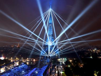 Pemandangan Menara Eiffel dan laser yang menerangi langit, selama upacara pembukaan Olimpiade Paris 2024, Jumat (26/7/2024). (Cheng Min / POOL / AFP)