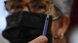 Perawat bersiap menyuntikkan dosis ketiga vaksin COVID-19 AstraZeneca di Centro de Estudios Superiores Navales (CENCIS) di Mexico City, Selasa (7/12/2021). Ibu kota Meksiko pada hari Selasa mulai memberikan vaksinasi booster untuk orang yang berusia di atas 60 tahun. (Pedro PARDO/AFP)