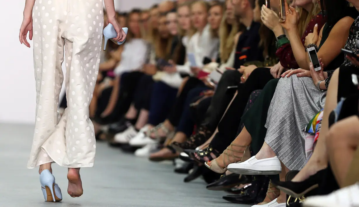 Seorang model berjalan di atas catwalk London Fashion Week 2017 dengan hanya mengenakan sebelah sepatunya di London, Inggris, Selasa (20/9).  Model itu mengalami insiden memalukan saat memperagakan busana rancangan Emilio De la Morena. (REUTERS/Neil Hall)