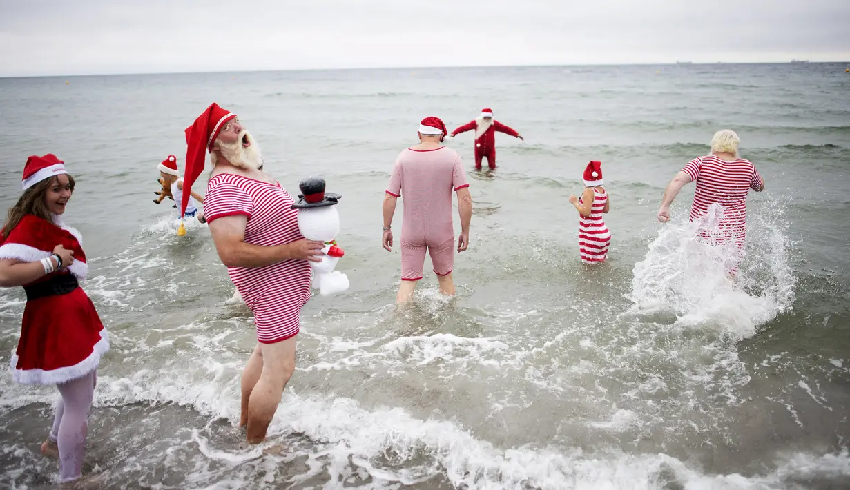 Sejumlah peserta Kongres Santa Claus Dunia 2015 berenang di pantai Bellevue di Copenhagen, Denmark, Minggu (21/7/2015). (REUTERS/Scanpix Denmark/Erik Refner)