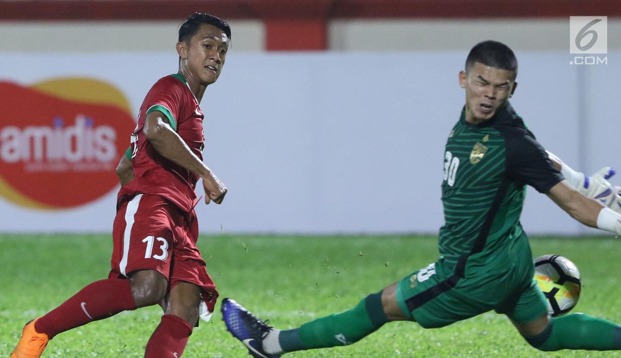 Pemain sayap Timnas Indonesia U-23, Febri Hariyadi (kiri) mencoba mengecoh kiper Thailand U-23, Kwanchai Suklom pada laga persahabatan di Stadion PTIK, Jakarta, Kamis (31/5). Indonesia U-23 kalah 1-2. (Liputan6.com/Helmi Fithriansyah)