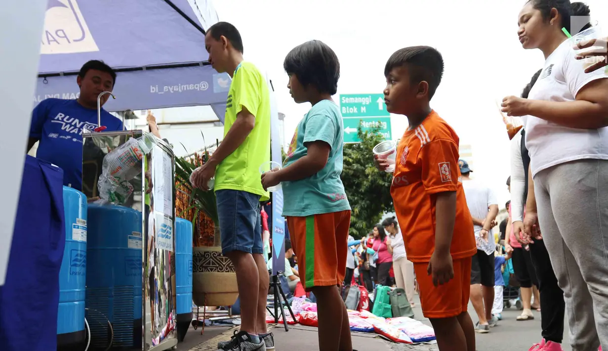Warga mengantre mengambil air minum gratis saat run for water di CFD, Jakarta, Minggu (25/3). Run For Water kolaborasi PAM Jaya, Palyja, dan Aetra mengkampanyekan Hari Air Dunia 2018 mengajak masyarakat ayo peduli air Jakarta. (Liputan6.com/Angga Yuniar)