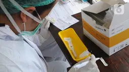 Paramedis Siloam Hospitals memeriksa sampel darah saat Rapid Test mandiri COVID -19 secara drive thru di Akses Senayan Park Jalan Gerbang Pemuda, Jakarta, Kamis (23/4/2020). Rapid Tes Covid -19 dibanderol seharga Rp 489.000, periode 17-30 April 2020 pukul 08.00-10.00 WIB. (merdeka.com/Arie Basuki)