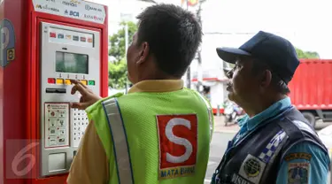 Petugas parkir melakukan transaksi dengan mesin terminal parkir elektronik (TPE) di jalan Sabang, Jakarta, Kamis (25/2). Pemprov DKI Jakarta berencana menambah mesin terminal parkir elektronik (TPE) atau parkir meter. (Liputan6.com/Yoppy Renato)