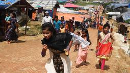Bocah-bocah Rohingya mengenakan pakaian baru selama perayaan Idul Adha di kamp pengungsi Thangkhali, Bangladesh, Rabu (22/8). Wajah riangnya senapas dengan baju baru yang dikenakan di hari bahagia ini. (Dibyangshu SARKAR / AFP)