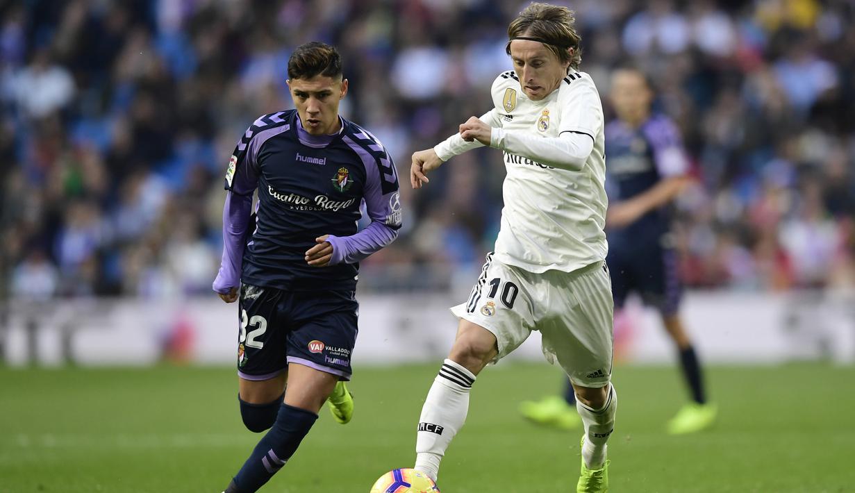 Gelandang Real Madrid, Luka Modric, berusaha melewati gelandang Real Valladolid, Leo Suarez, pada laga La Liga Spanyol di Stadion Santiago Bernabeu, Madrid, Sabtu (3/11). Madrid menang 2-0 atas Valladolid. (AFP/Javier Soriano)