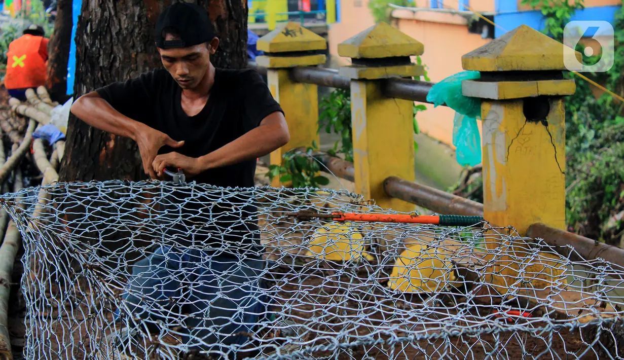 Pekerja membuat bronjong untuk menahan longsor susulan di Jalan Raya Tanah Baru, Depok, Jawa Barat, Kamis (9/1/2020). Sebelumnya, beberapa titik sepanjang Jalan Raya Tanah Baru mengalami longsor akibat hujan deras yang melanda. (merdeka.com/Magang/Muhammad Fayyadh)