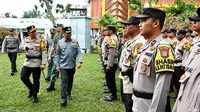 Kapolresta Pekanbaru Jeki Rahmat Mustika mengecek barisan Bhabinkatimbas yang diturunkan memantau TPS. (Liputan6.com/M Syukur)