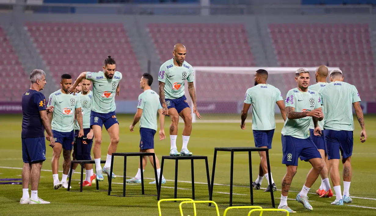 Pemain Brasil Dani Alves (tengah) dan rekan satu timnya berolahraga saat sesi latihan di Stadion Grand Hamad, Doha, Qatar, 29 November 2022. Brasil akan menghadapi Kamerun dalam pertandingan sepak bola Grup G Piala Dunia 2022 pada 2 Desember. (AP Photo/Andre Penner)