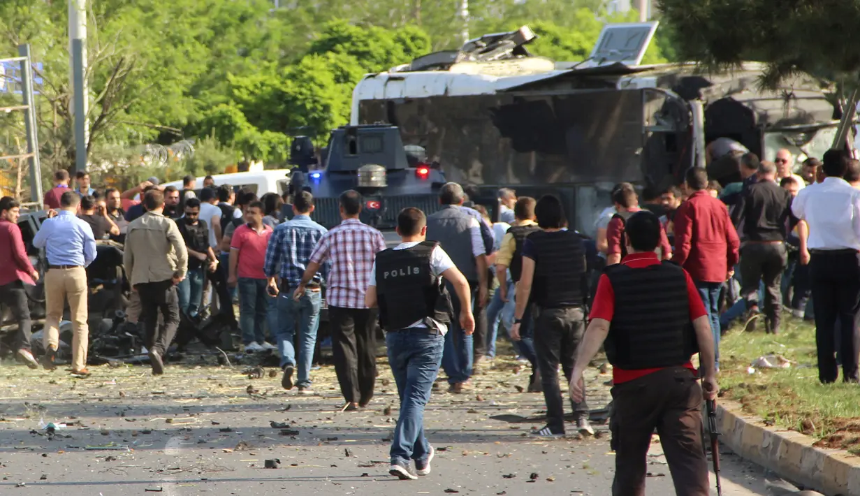 Petugas polisi berpakaian preman berdatangan ke lokasi ledakan bom mobil di kota Diyarbakir, Turki, Selasa (10/5). Ledakan menghantam kendaraan lapis baja polisi, setidaknya tiga korban tewas dan puluhan mengalami luka-luka (Ihlas News Agency via REUTERS)