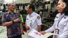 Ketua Komisi Pemilihan Umum (KPU) Hasyim Asy'ari (kiri) saat meninjau panggung debat Capres/Cawapres Pemilu 2024 di Halaman Gedung KPU, Jakarta, Senin (11/12/2023). (Liputan6.com/Angga Yuniar)