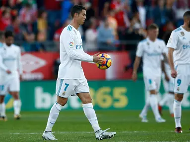Striker Real Madrid Cristiano Ronaldo membawa bola ke tengah lapangan usai gawangnya kebobolan dari Girona saat pertandingan La Liga di stadion Montilivi di Girona, Spanyol (29/10). (AP Photo/Manu Fernandez)