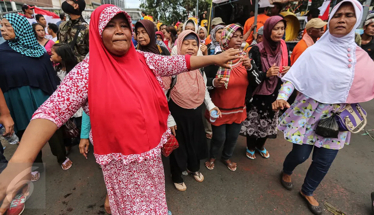 Sejumlah ibu menari mengiringi Sisingaan Jaipong dalam parade kebudayaan "Aksi Kita Indonesia" di Bundaran HI, Jakarta, Minggu (4/12). Parade kebudayaan itu menampilkan berbagai pertunjukan kesenian dari Sabang sampai Merauke.  (Liputan6.com/Fery Pradolo)