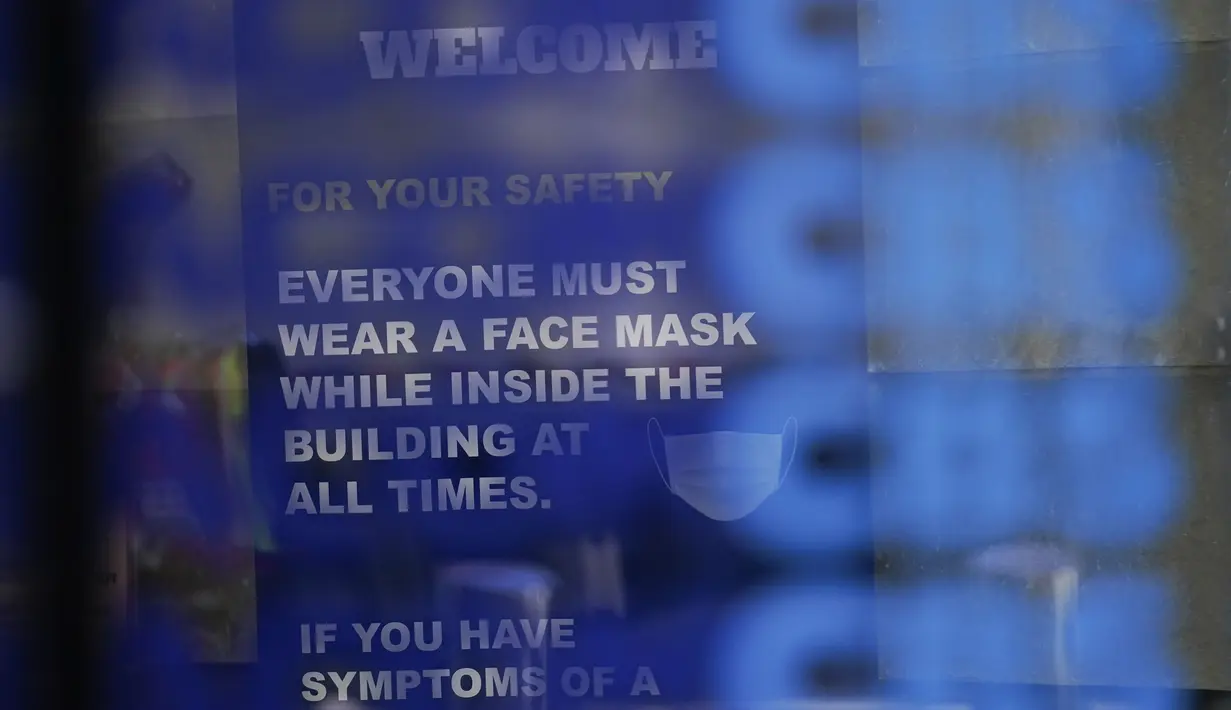 Sebuah tanda mengingatkan orang-orang bahwa masker diperlukan di sebuah gedung perkantoran di Times Square New York, Senin (13/12/2021). Wajib masker di semua tempat umum dalam ruangan di seluruh New York mulai berlaku pada Senin ketika lonjakan kasus COVID-19 dan rawat inap. (AP Photo/Seth Wenig)