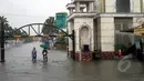Dua orang warga melintasi banjir di kawasan Perumahan Bulevar Hijau Harapan Indah, Bekasi, Senin (9/2/2015). (Liputan6.com/Panji Diksana)