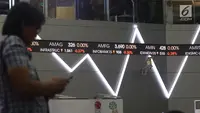Pengunjung melintas dekat layar monitor pergerakan saham di gedung Bursa Efek Indonesia, Jakarta, Rabu (2/1). Indeks Harga Saham Gabungan (IHSG) pada pembukaan perdagangan saham 2019 menguat 10,4 poin atau 0,16% ke 6.204. (Liputan6.com/Angga Yuniar)