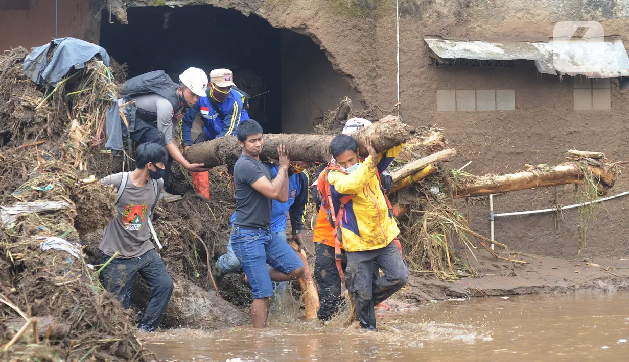 Tim SAR gabungan TNI, Polri, dan relawan membersihkan material longsor usai banjir bandang menerjang Kampung Cibuntu, Desa Pasawahan, Kecamatan Cicurug, Sukabumi, Selasa (22/9/2020). Banjir mengakibatkan puluhan bangunan rusak berat, 12 rumah hanyut, dan dua korban hilang. (merdeka.com/Arie Basuki)