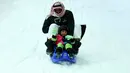 Seorang pria dan anaknya berseluncur menikmati bermain salju di Snow City di Mall Al Othaim, Riyadh, Arab Saudi (26/7). (REUTERS/Faisal Al Nasser)