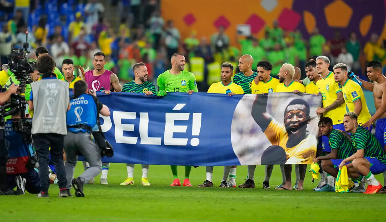 Para pemain Brasil membentangkan spanduk dukungan untuk Pele yang sedang sakit pada akhir pertandingan sepak bola babak 16 besar Piala Dunia 2022 antara Brasil dan Korea Selatan di Stadium 974, Doha, Qatar, 5 Desember 2022. (AP Photo/Jin-Man Lee)