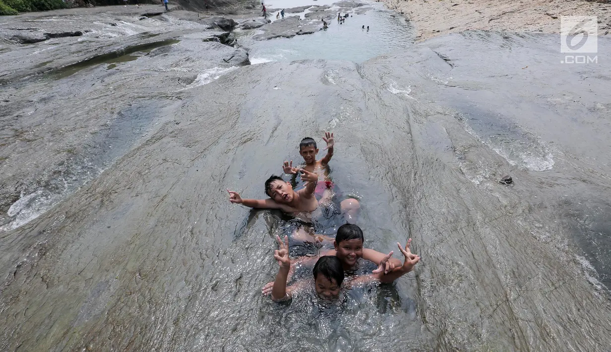 Anak-anak berendam di aliran sungai Gunung Sari, Desa Tajur, Pasirmukti, Citeureup, Bogor, Jawa Barat (24/6/2019). Wisata gratis ini adalah salah satu wahana rekreasi baru warga disekitaran Cibinong dan Citeureup sambil membawa anak anaknya main dan mandi disungai. (Kapanlagi.com/Budy Santoso)
