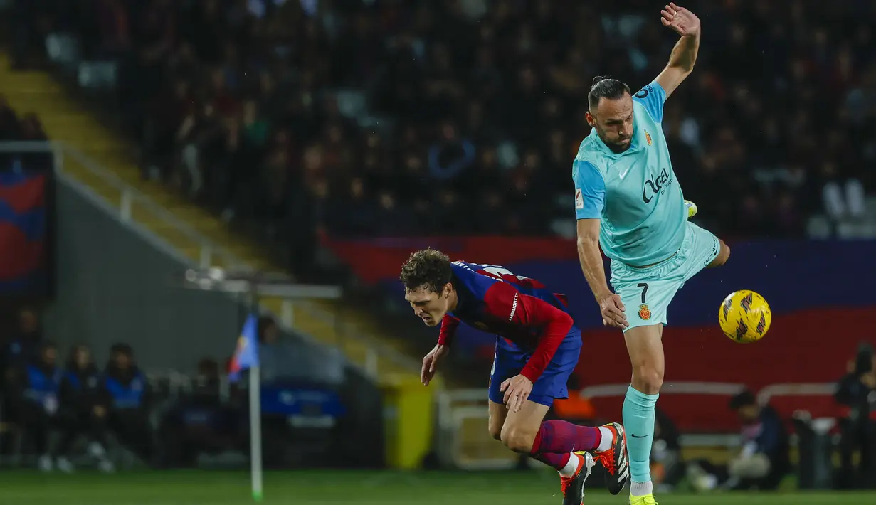 Bek Barcelona, Andreas Christensen (kiri) berebut bola dengan striker Mallorca, Vedat Muriqi pada laga pekan ke-28 LaLiga 2023/2024 yang berlangsung di Olimpic Lluis Companys Stadium, Barcelona, Sabtu (9/3/2024) dini hari WIB. (AP Photo/Joan Monfort)