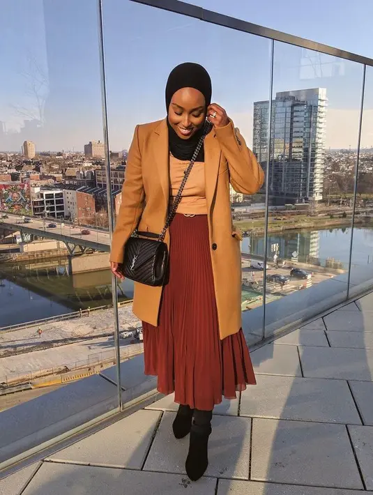 Kombinasi top dan blazer warna nude juga tak kalah menarik dipadukan dengan rok plisket midi warna maroon. Kenakan sepatu boots agar gaya makin modis (Instagram/ayshaharun).