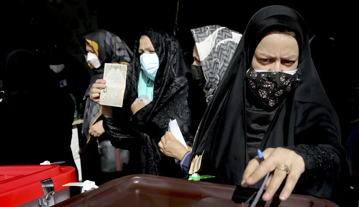 Seorang pemilih memberikan suaranya untuk pemilihan presiden di sebuah tempat pemungutan suara di Teheran, Iran, Jumat (18/6/2021). Warga Iran mulai memberikan suaranya dalam pemilihan presiden. (AP Photo/Ebrahim Noroozi)