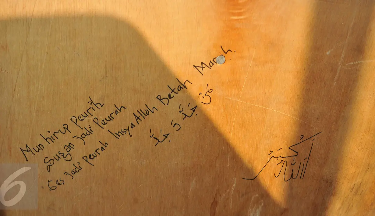 Sebuah kalimat tampak tertulis di pintu rumah warga di Kampung Dadap, Tangerang, Rabu (18/5). Dahulu, kawasan itu merupakan perkampungan nelayan karena letaknya yang dekat dengan pantai utara Jawa dan ramainya pendatang. (Liputan6.com/Gempur M Surya)