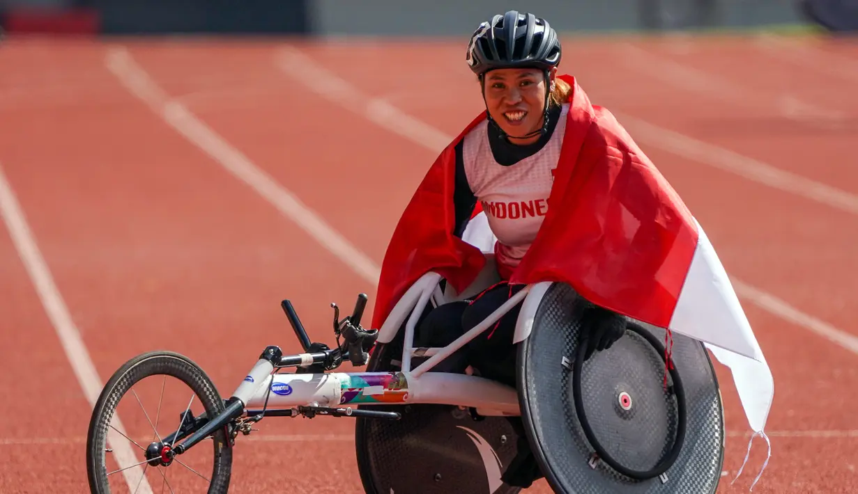 Atlet balap kursi roda Maria Goreti melakukan selebrasi usai memenangi final balap kursi roda 400 meter putri 11th ASEAN Para Games 2022 di Stadion Manahan, Solo, Jawa Tengah, Kamis (4/8/2022). Maria Goreti meraih medali emas pada final tersebut. (INASPOC/Feri Setiawan)