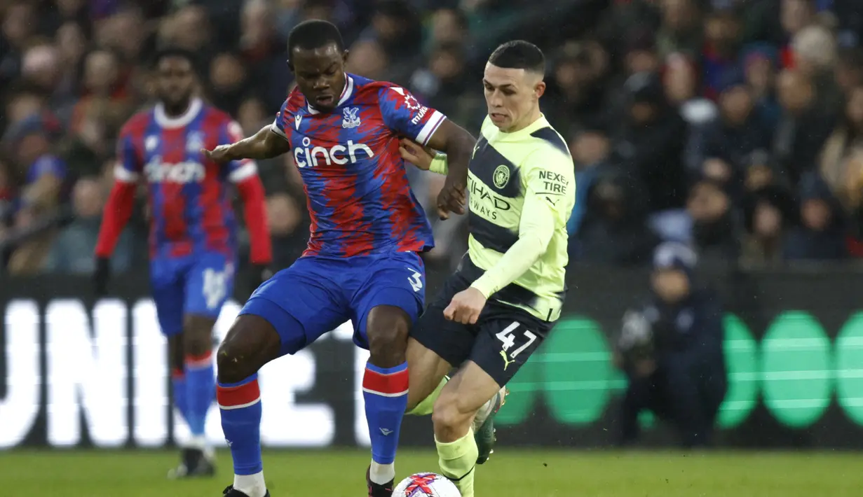 Gelandang Manchester City, Phil Foden berebut bola dengan pemain Crystal Palace, Tyrick Mitchell selama pertandingan lanjutan Liga Inggris di stadion Selhurst Park, di London, Minggu (12/3/2023). Hasil ini membuat Manchester City memangkas jarak dengan pemuncak klasemen sementara Premier League,Arsenal. City mengoleksi 61 poin, beda 2 angka dari Arsenal. (AP Photo/David Cliff)